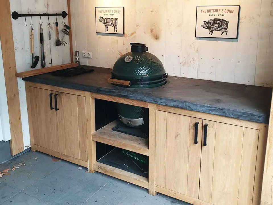Eikenhouten buitenkeuken met een donker werkblad en een kamado-barbecue