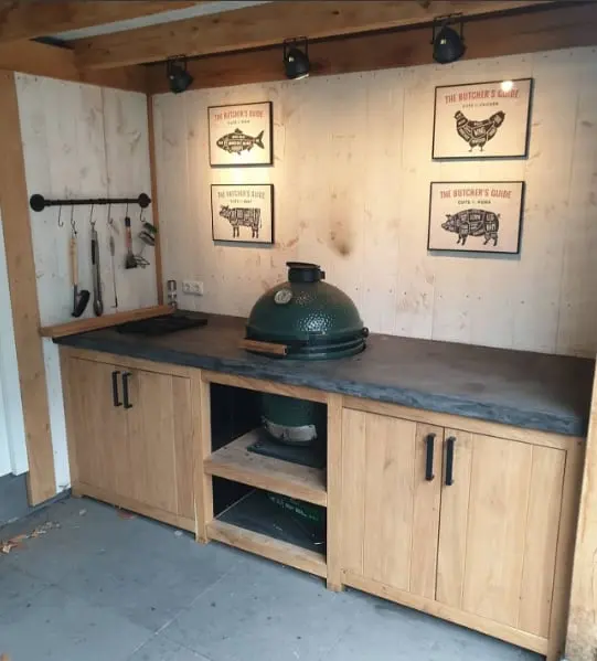 Eikenhouten buitenkeuken met een kamado-barbecue en wandborden