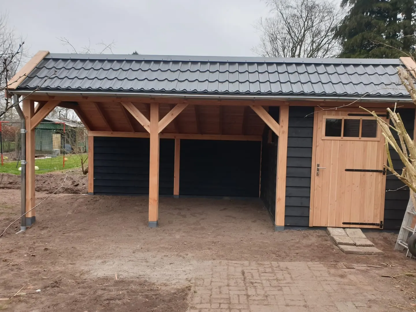 Houten carport met pannendak en een dichte berging