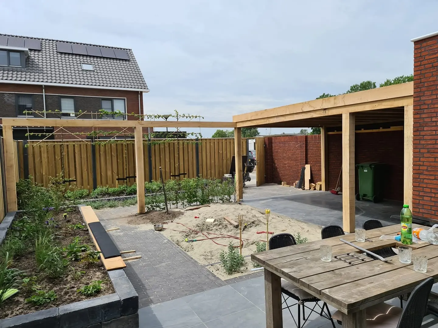 Houten overkapping en pergola in een nieuw aangelegde tuin