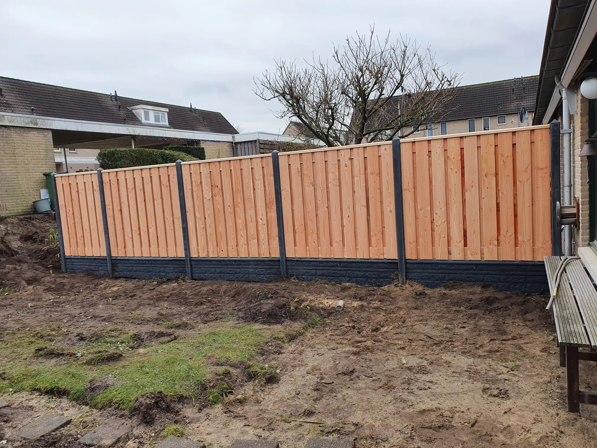 Nieuwe hout-betonschutting in een tuin
