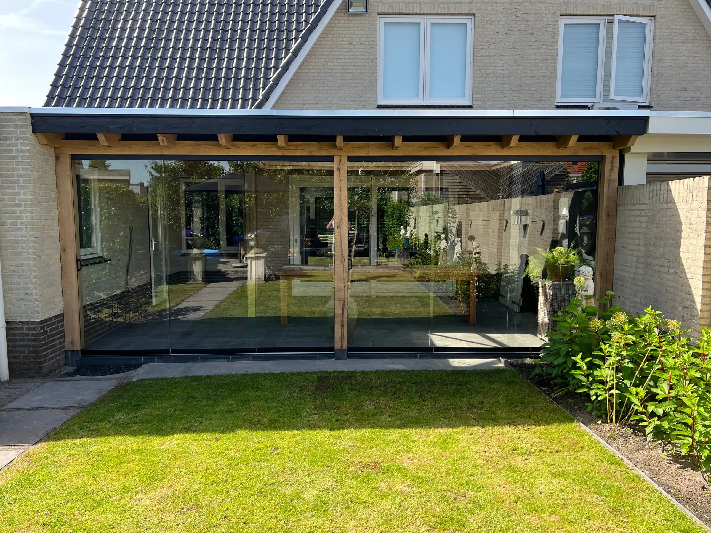 Veranda met glazen schuifwanden over de volle breedte van de achtergevel, in Raamsdonk